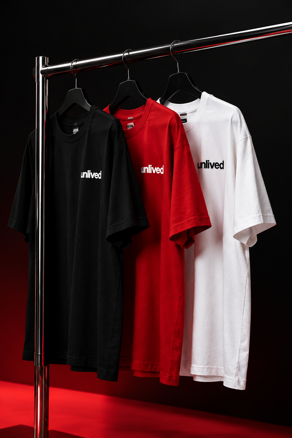 Trois personnes portant les t-shirts rouges UNLIVED dans un bureau moderne
